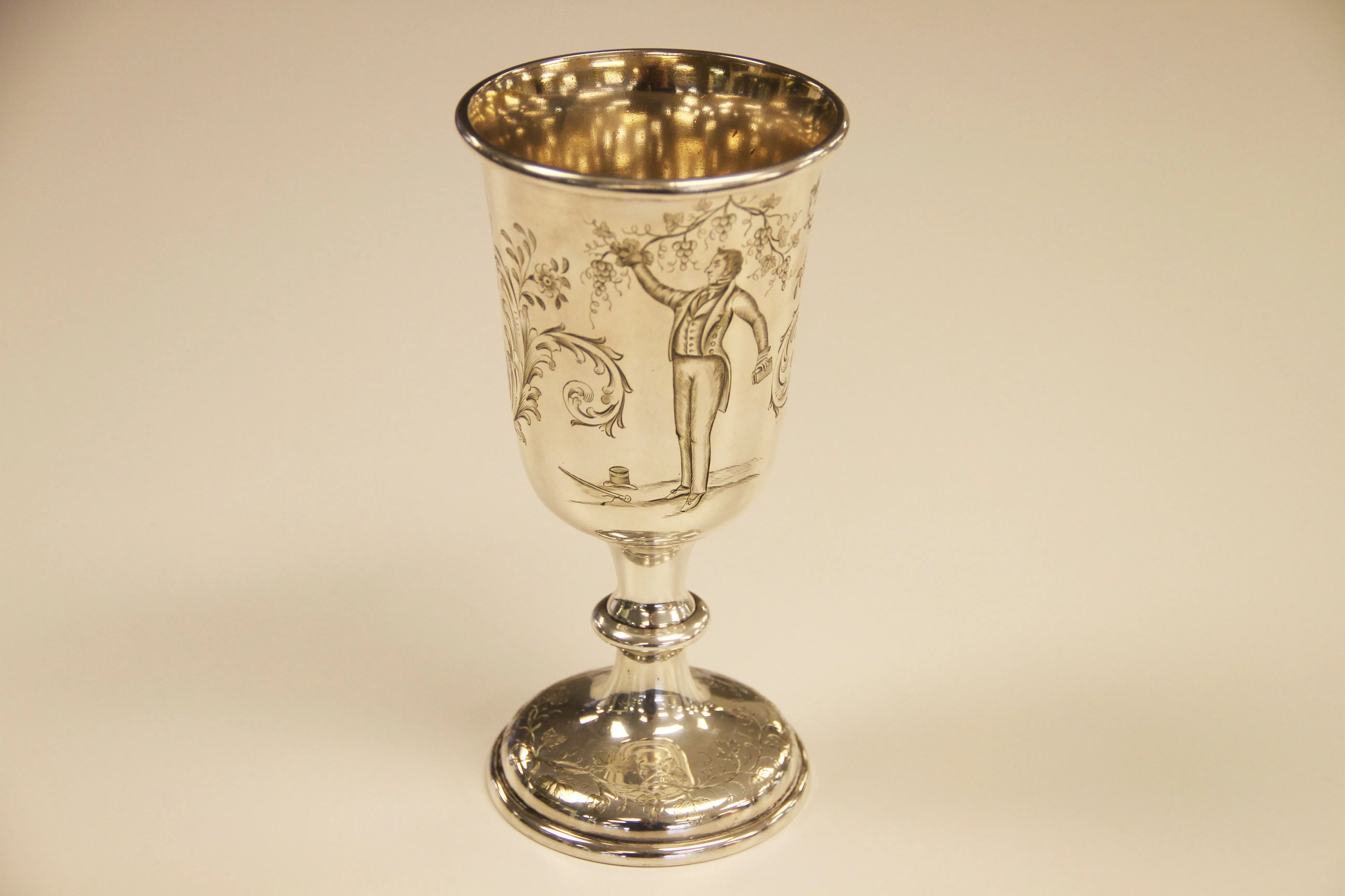 Une image d’un gobelet en argent datant de 1847 sur un fond uni, utilisé lors des services de Sainte-Cène des saints des derniers jours ou des mormons, avec une image gravée de Joseph Smith parmi des vignes.