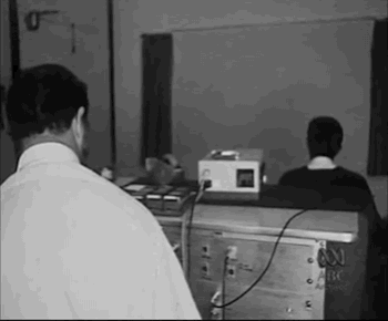 Ein animiertes GIF der ABC, also der Australian Broadcasting Corporation, aus dem Mai 1970, das einen Arzt und einen Patienten bei einer Aversionstherapie mit Dias von Männern und Frauen und einem Elektroschockgerät zeigt. Schwarz-weißes Archivmaterial.